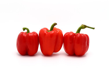 Three red ripe sweet peppers on a light background. Natural product. Natural color. Close-up.