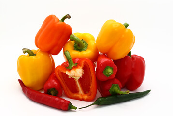 Composition of several sweet peppers and their halves of different colors on a light background. Natural product. Natural color. Close-up.