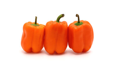 Three ripe sweet orange peppers on a light background. Natural product. Natural color. Close-up.