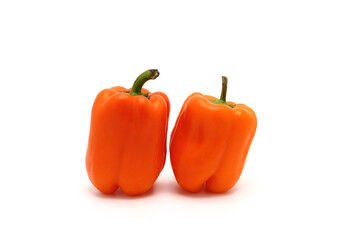 Two sweet peppers of orange color on a light background. Natural product. Natural color. Close-up.