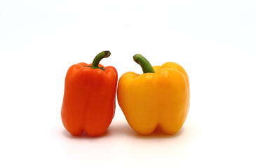 Two sweet peppers of yellow and orange color on a light background. Natural product. Natural color. Close-up.