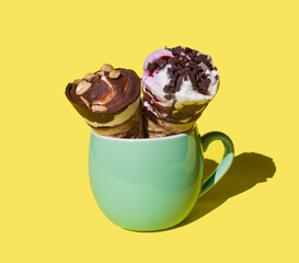Ice cream in the horn. Ice cream in a horn on a yellow background in a green cup. copyspace