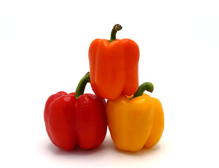 Three sweet peppers of yellow, red and orange color on a light background. Natural product. Natural color. Close-up.