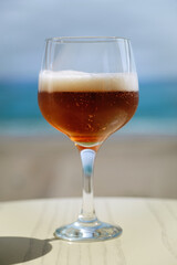 Glass of beer on the beach. Shallow depth of field