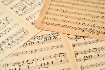 Fotobehang Old sheets with music notes scattered on the table. Close-up. Retro style. Selective focus. © zdravinjo