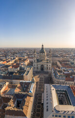 Aerial drone shot of St. Stephen's Basilica with empty square in Budapest sunrise glow