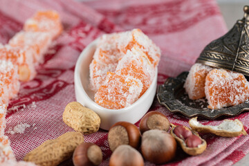 Colorful lokum candies in a white saucer with nuts