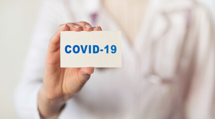 Doctor holding card with sign COVID-19. Health concept