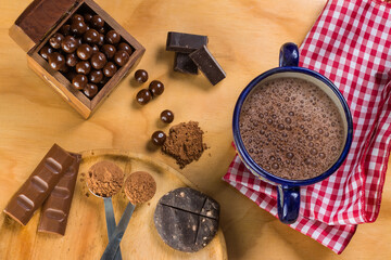 cocoa hot chocolate served in artisan cup accompanied by different presentations of cocoa in...