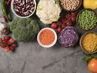Set of fresh vegetables, fruits and legumes on a gray background.