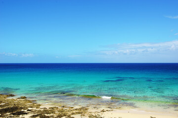 Tropical beach, azure ocean water and blue sky. Paradise landscape.