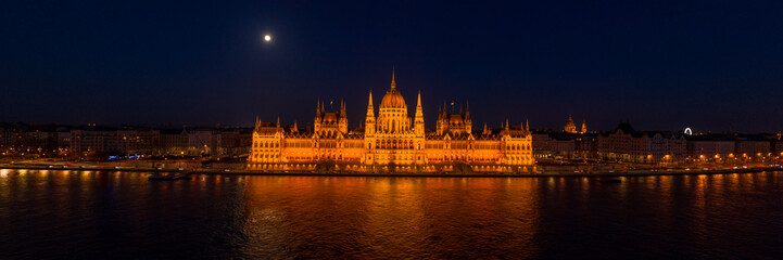 Fototapeta na wymiar Panoramic aerial drone shot of front facade of Hungarian Parliament with lights on in Budapest night