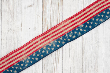Retro USA stars and stripes burlap ribbon on weathered whitewash wood background