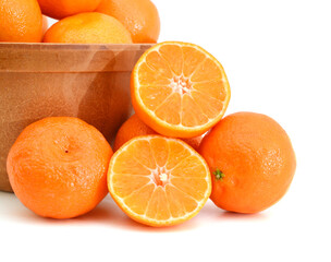 orange mandarines heap in wooden bowl on white