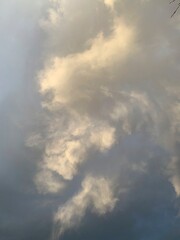 A closeup of gray, gold, and silver clouds at sunset in the sky.