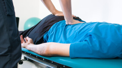 Obraz premium Physiotherapist exercising with disabled person on a therapy table.