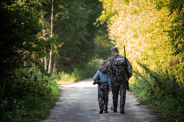 Father and son hunting together. Walking the road after the bird hunt.