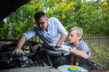 Father teaching his son how to repair the car