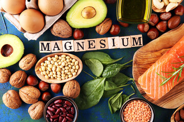 Products containing magnesium: bananas, almonds, avocado, nuts and spinach and eggs on background