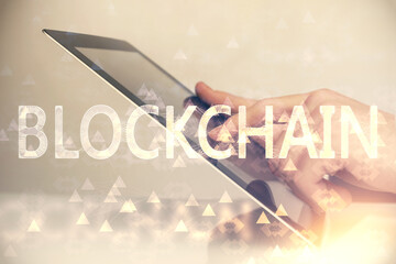 Double exposure of man's hands holding and using a phone and crypto currency blockchain theme...