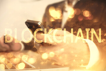 Double exposure of man's hands holding and using a phone and crypto currency blockchain theme drawing.