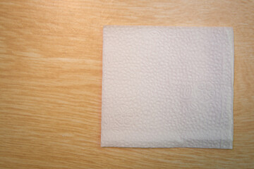 Blank paper napkin isolated on wooden background with copy space . White napkin on wooden background, many views of white napkins, blank mockup files .White Square Bar Napkin on wooden Background .
