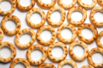 Tasty golden bagels. Mini round bagels texture, background. Top view.