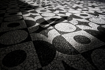 Foto em preto e branco das paternas da calçada de pedra em Curitiba, Paraná.