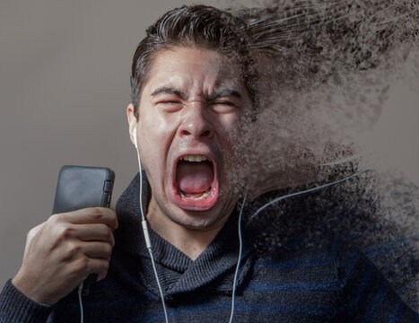 Angry screaming man frustrated by technology holding a mobile phone while his head is exploding