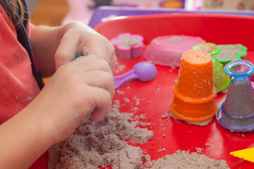 little hands playing with kinetic sand