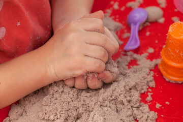 little hands playing with kinetic sand