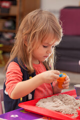 little girl playing with kinetic sand