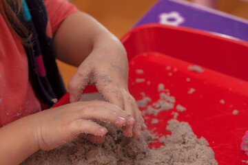 little hands playing with kinetic sand