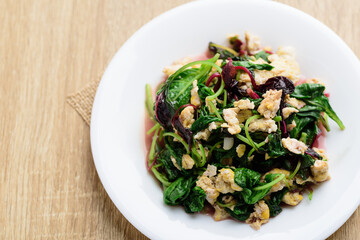 Stir fried Thai spinach with egg on white dish, Healthy Thai food