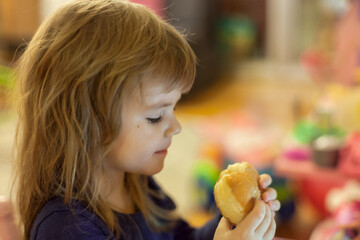 a little girl eating a donut