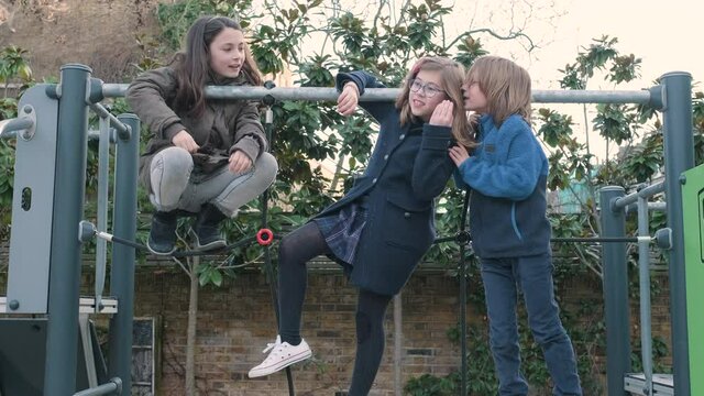 Children playing telephone game on the schoolyard during break time
