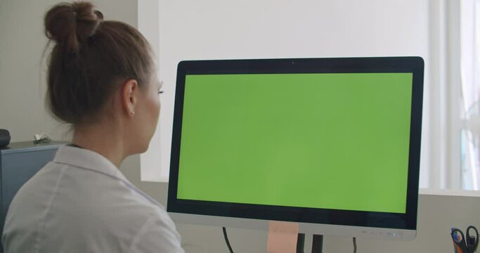 Doctor work on computer with green mock-up screen