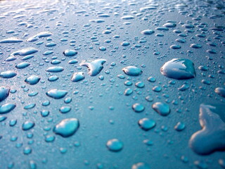 Dew drops on the roof of the blue car Use as background.