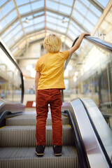 Behavior rules on escalator, in transport, on streets of city. Little child standing on moving...