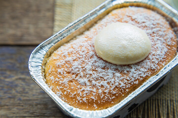 High angle views close up a cup of Hokkaido milk bread with topping cream on a wooden table.
