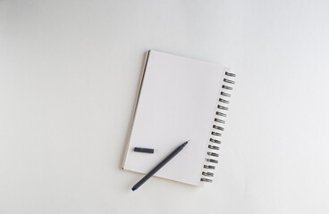 Open Notebook and a pen with pec cap on white background with a lot of space for copy text