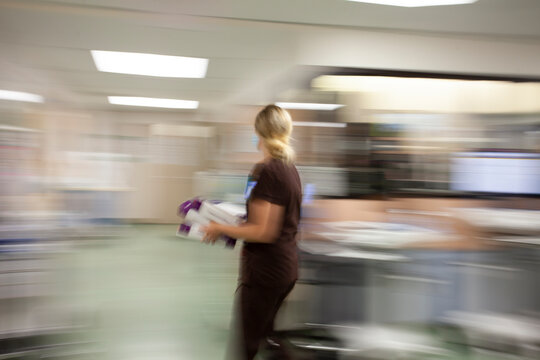 Female nurse rushing through nursing station to get care for coronnavirus patients