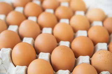 Close-up view of raw chicken eggs in egg box on wooden background. Raw chicken eggs in egg box organic food for good health high protein .