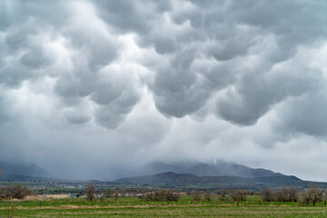 Mammatus clouds in the sky during rain storm over mountains in Utah