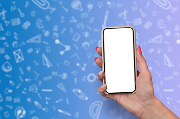 Back to School concept. Woman Hand holding the black Mockup smartphone with beautiful nails on the background with stationery icons. Mobile device isolated on purple colour.