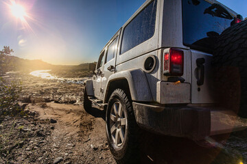 Jeep 4x4 from behind looking toward stream and sun Trabucco Canyon California - obrazy, fototapety, plakaty