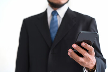 A bearded businessman holding a smartphone with a white background