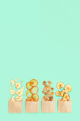 Plant based food concept. Dehydrated fruit chips of apple, banana, persimmon, pear as healthy snack or sweets. Top view and copy space.