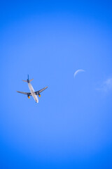 Airplane flying  next to the moon in a sunset of Santa Cruz de Tenerife, Spain