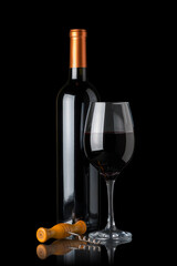 Bottle of red wine next to a glass and a corkscrew isolated on black background